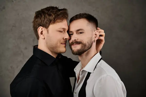 stock image A gay couple in elegant suits, embracing in a studio setting.