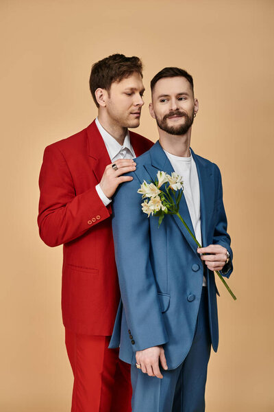 Двое мужчин в элегантных костюмах стоят рядом, демонстрируя свою любовь и привязанность.