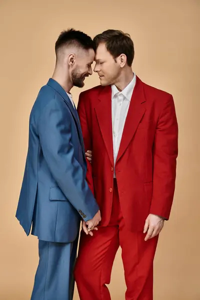 stock image Two men in elegant suits stand close together, foreheads touching, in a loving embrace.