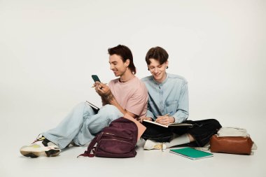 LGBTQIA topluluğunun bir parçası olan iki genç, sıradan giyinmiş ve birlikte okuyorlar..