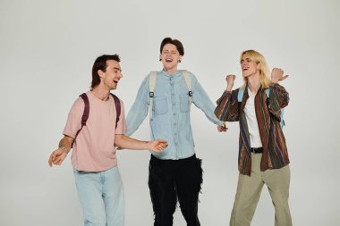 Homo topluluğunun bir parçası olan üç öğrenci birlikte gülüyor ve arkadaşlıklarını kutluyorlar..