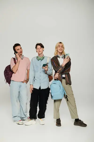 stock image Three young students stand together in a casual setting, showcasing LGBTQIA+ pride and friendship.