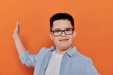Down sendromlu genç bir çocuk portrede ışıl ışıl gülümsüyor..