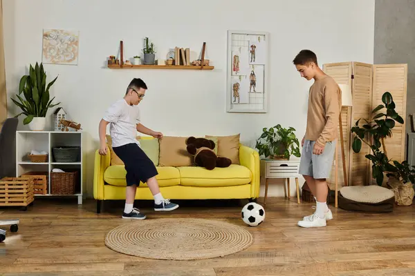 Oturma odasında iki çocuk futbol oynuyor..