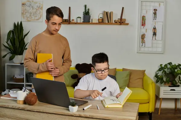 stock image A young boy with Down syndrome studies at home with his friends.