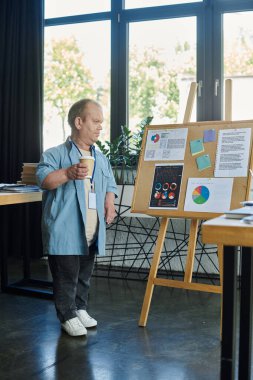 A man with inclusivity stands in an office, holding a coffee cup and reviewing charts on a whiteboard. clipart