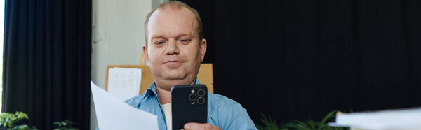 Человек с инклюзивностью изучает документы, держа телефон..