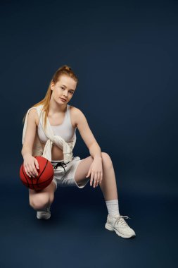 Güzel genç bir kadın, canlı bir arkaplanda basketbol topuyla poz veriyor..