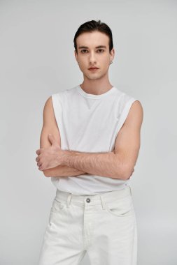 Beyaz atletli şık bir adam ve parlak bir arka fona karşı duran kot pantolon..