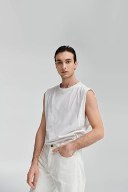 A man in a white tank top and jeans poses against a white background. clipart