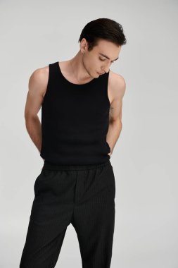 A man in a black tank top poses against a white backdrop. clipart