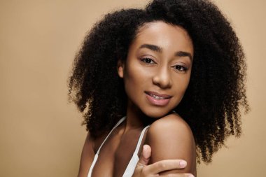 Güzel bir Afro-Amerikan kadının yakın plan portresi, doğal makyajlı, yavaşça gülümseyen..