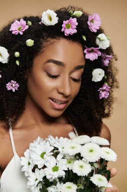 A beautiful African American woman with flowers in her hair, embracing a bouquet of white daisies. clipart