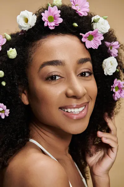 stock image A beautiful African American woman with flowers in her hair smiles warmly.