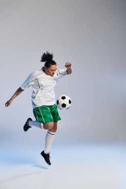Futbol formalı bir kadın beyaz bir arka planda topu havada hokkabazlık yapıyor..