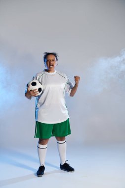 Futbolcu yumruğunu kaldırarak gol atmasını kutluyor.