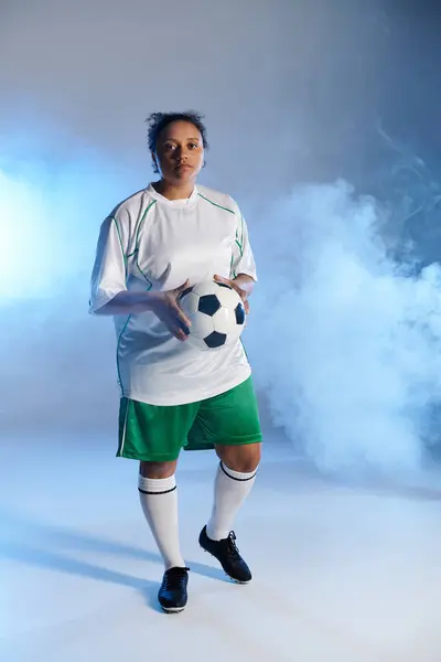 stock image Athletic woman in white jersey ready for soccer in smoky studio.