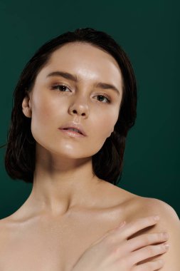 Güzel bir kadın yeşil bir zemin ile poz verir..