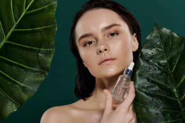 Bir kadın yüzüne büyük yeşil yapraklarla çevrili bir serum uygular..