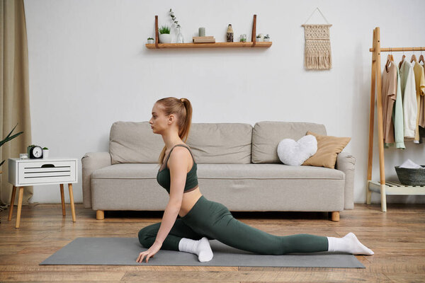 Young woman stretching on a yoga mat in her living room.