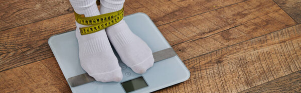Женские ступни на весах, связанные скотчем, когда она проверяет свой прогресс.