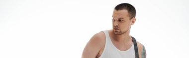 Shaved head, short beard man in white tank top against white backdrop. clipart