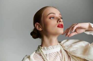 A young woman in a white blouse and pearl necklace gazes upwards. clipart