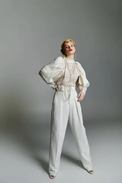 stock image A stylish young woman wearing a white blouse and wide-leg trousers poses for a photograph.