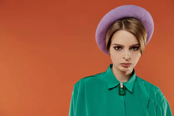 stock image A stylish woman with dark makeup and a purple beret poses confidently in a green shirt.