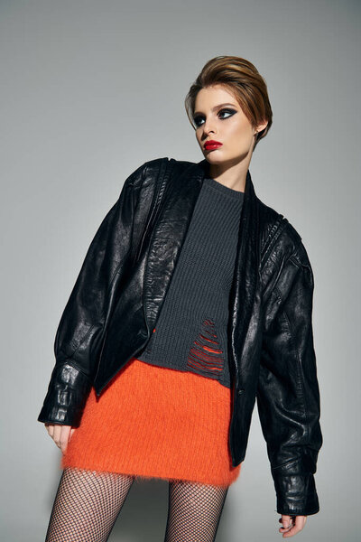 Стильная женщина в кожаной куртке, пушистая юбка, рыбные сети позируют уверенно.