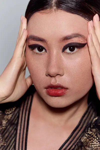 stock image A close-up of a beautiful Asian woman, her eyes captivating with bold eyeliner.