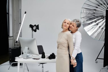 Yetişkin bir lezbiyen çift stüdyoda fotoğraf çekerken samimi pozlar veriyor..