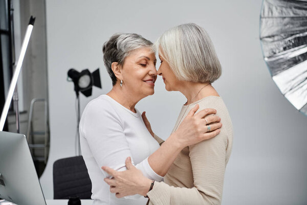Two women, a photographer and her model, embrace in a photo studio, their love a silent testament to their enduring bond.