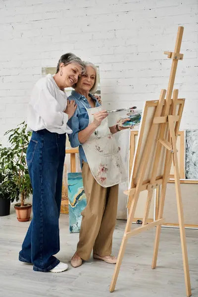 stock image A lesbian couple paints together in an art studio, sharing a moment of creativity and love.