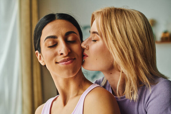 A lesbian couple shares a loving embrace in their home.