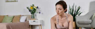 Ekin giysili güzel bir Asyalı kadın modern bir dairede yoga ve meditasyon yapıyor..