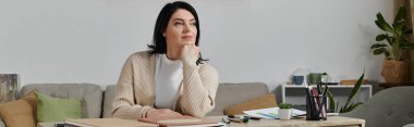 Tekerlekli sandalyede oturan bir kadın, çenesini elinin üzerine koyup, uzaklara bakıyor..
