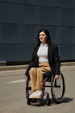 Tekerlekli sandalyedeki bir kadın umut dolu bir ifadeyle şehir caddesinde yuvarlanıyor..
