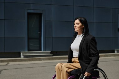 Tekerlekli sandalyedeki bir kadın ufukta kendine güvenen bir şekilde gülümsüyor..