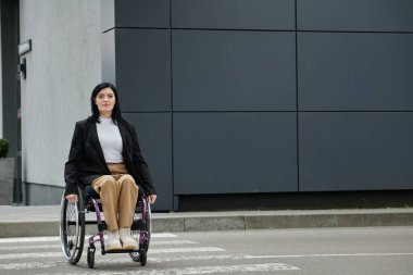 Tekerlekli sandalyedeki bir kadın şehir caddesini geçiyor..