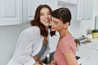 Genç bir çift, mutfaklarında sıcak bir anın tadını çıkarır, sıcak bir kucaklaşmayı paylaşırlar..