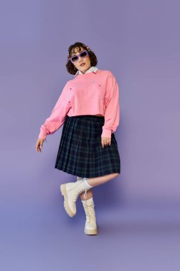 Pembe kazaklı ve ekose etekli bir kadın lavanta arka planında poz veriyor..