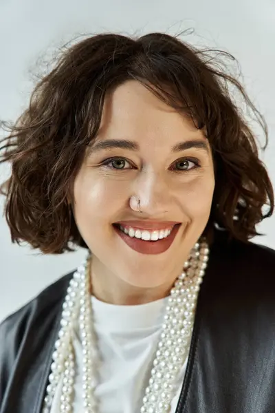 stock image Woman in leather jacket, pearl necklace, smiling with short curly hair