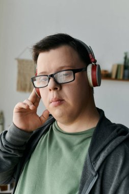 Down sendromlu genç bir adam evde dinlenirken müzik dinliyor..