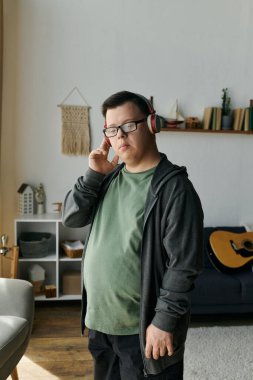 Down sendromlu genç bir adam evde dinlenirken en sevdiği melodilerden hoşlanır..