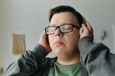 Down sendromlu genç bir adam müzik dinlerken huzurlu bir anın tadını çıkarır..