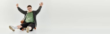 Down sendromlu bir adam kolları açık otururken mutluluğunu ifade eder..