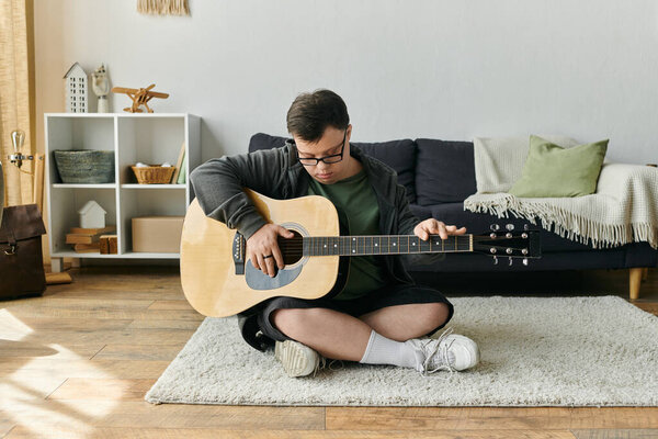 Радостный человек с синдромом Дауна играет на гитаре, сидя на мягком ковре.