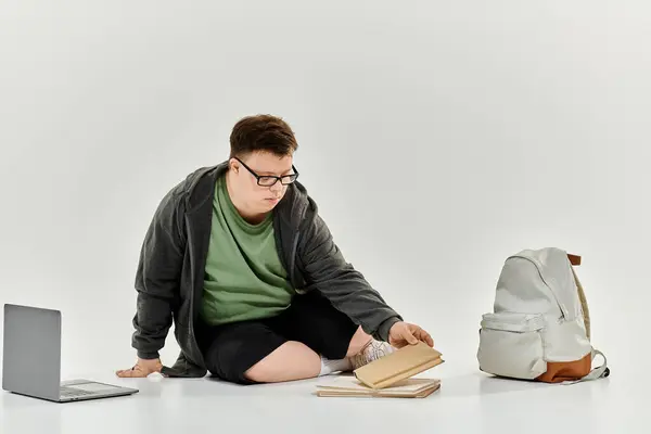 stock image A young man with Down syndrome enjoys reading books in his cozy home setting.