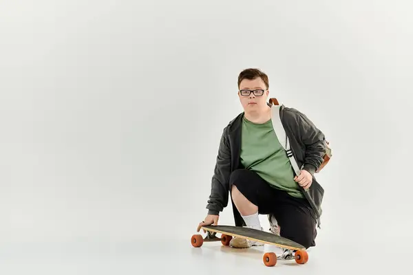 stock image A young man with Down syndrome engages with his skateboard in a serene indoor space.